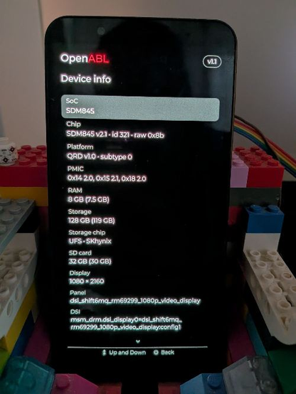 A photo of a SHIFT6mq in a LEGO "dock". The screen shows OpenABL's device info with SoC, RAM and other information.